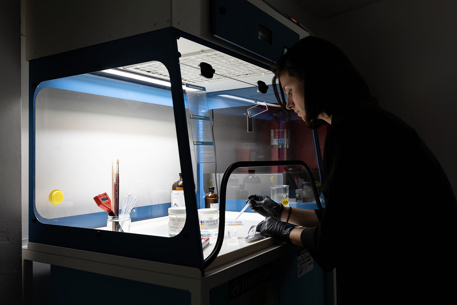 Paintings Conservator, Bitzy Couling, prepares chemical solutions under a fume hood